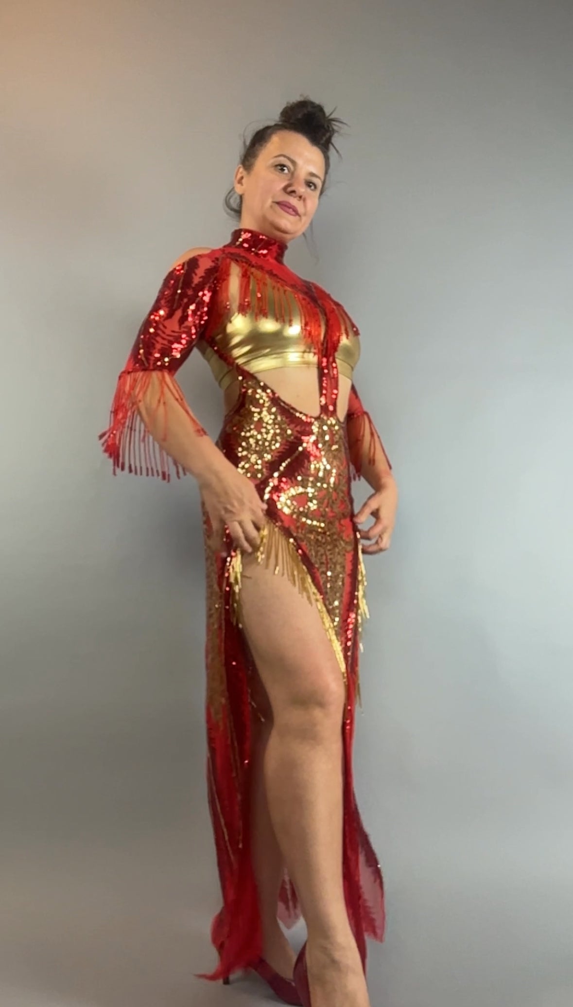 Woman posing in the bearded French accessories Sequin Sheer Dress—backless with beaded fringe accessories—against a gray background.