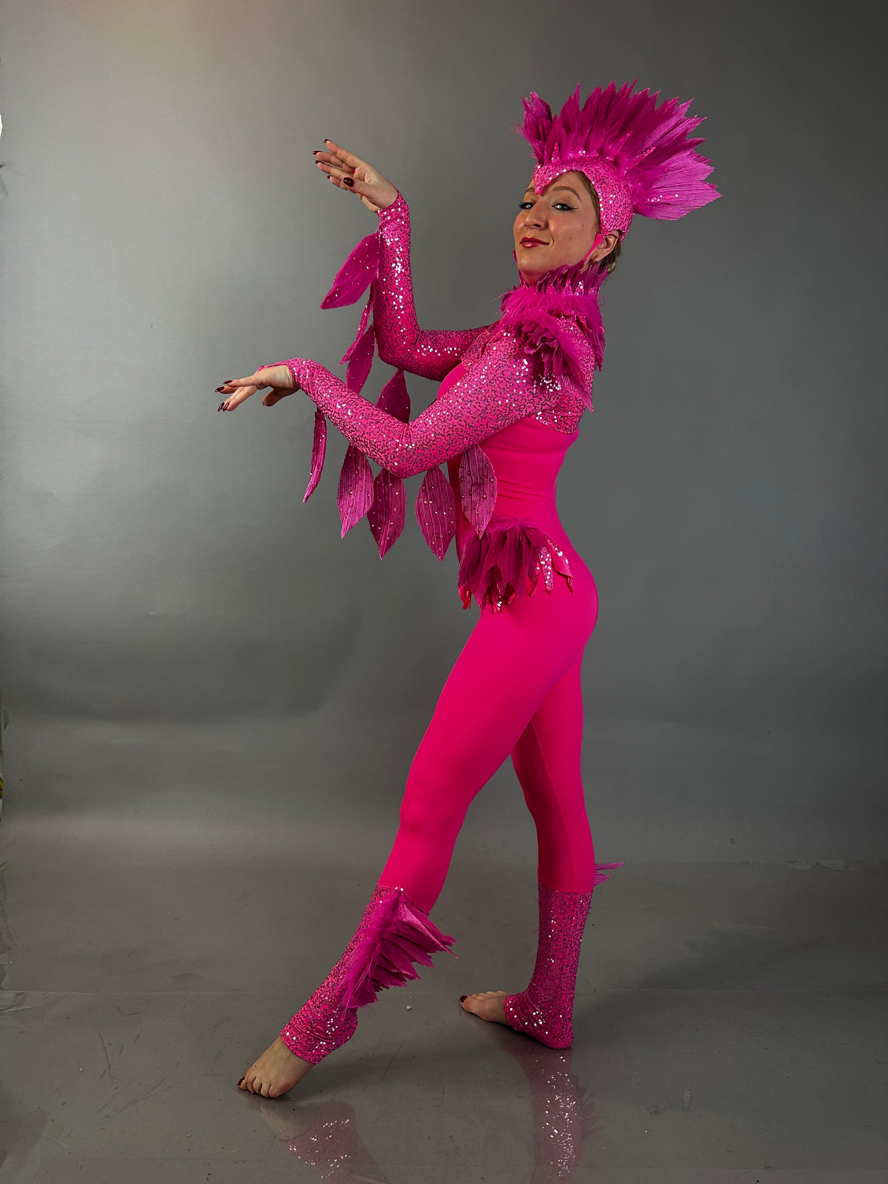 Model elegantly displays the Pink bird full costume for aerial and dancers, featuring vibrant pink feathers, set against a simple grey background—ideal for standout theatrical performances.