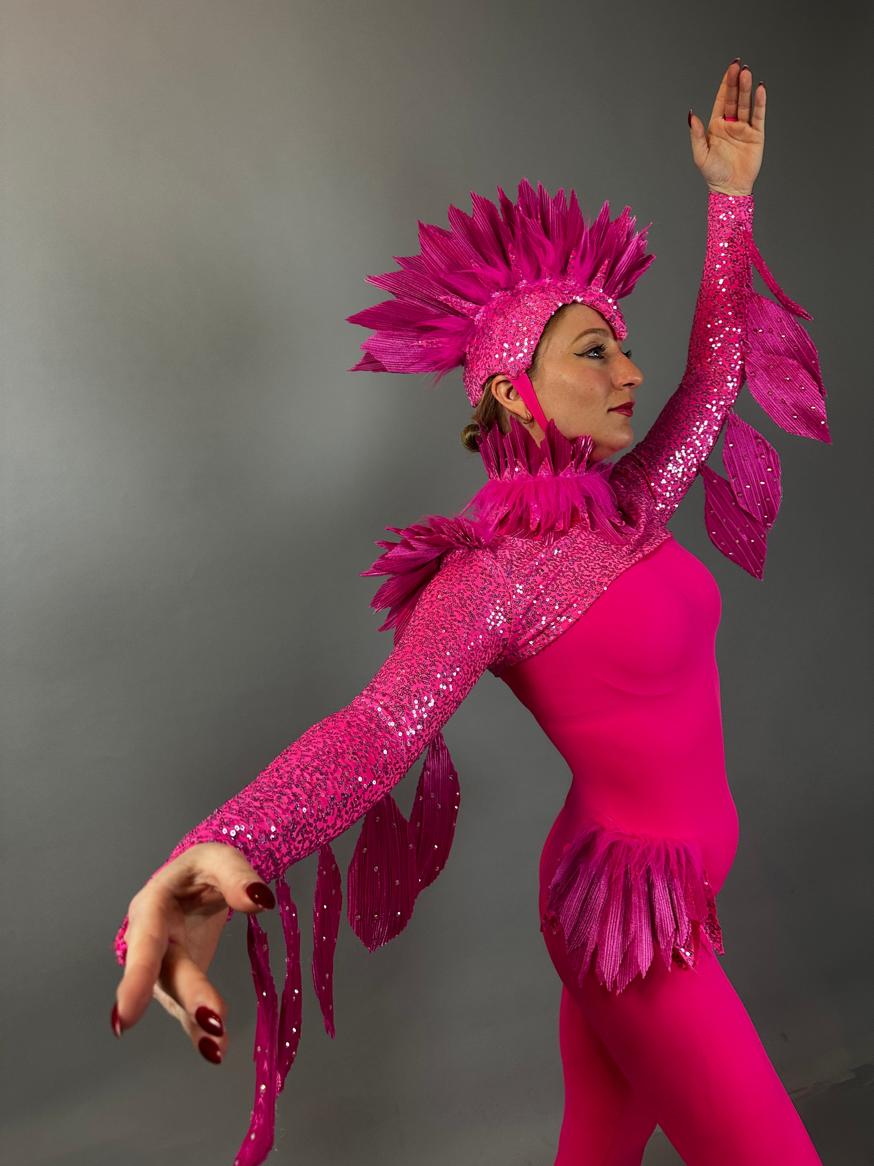 A person wears the Pink bird full costume for aerial and dancers, posing with arms raised against a gray background—ideal for stage or theatrical performances.