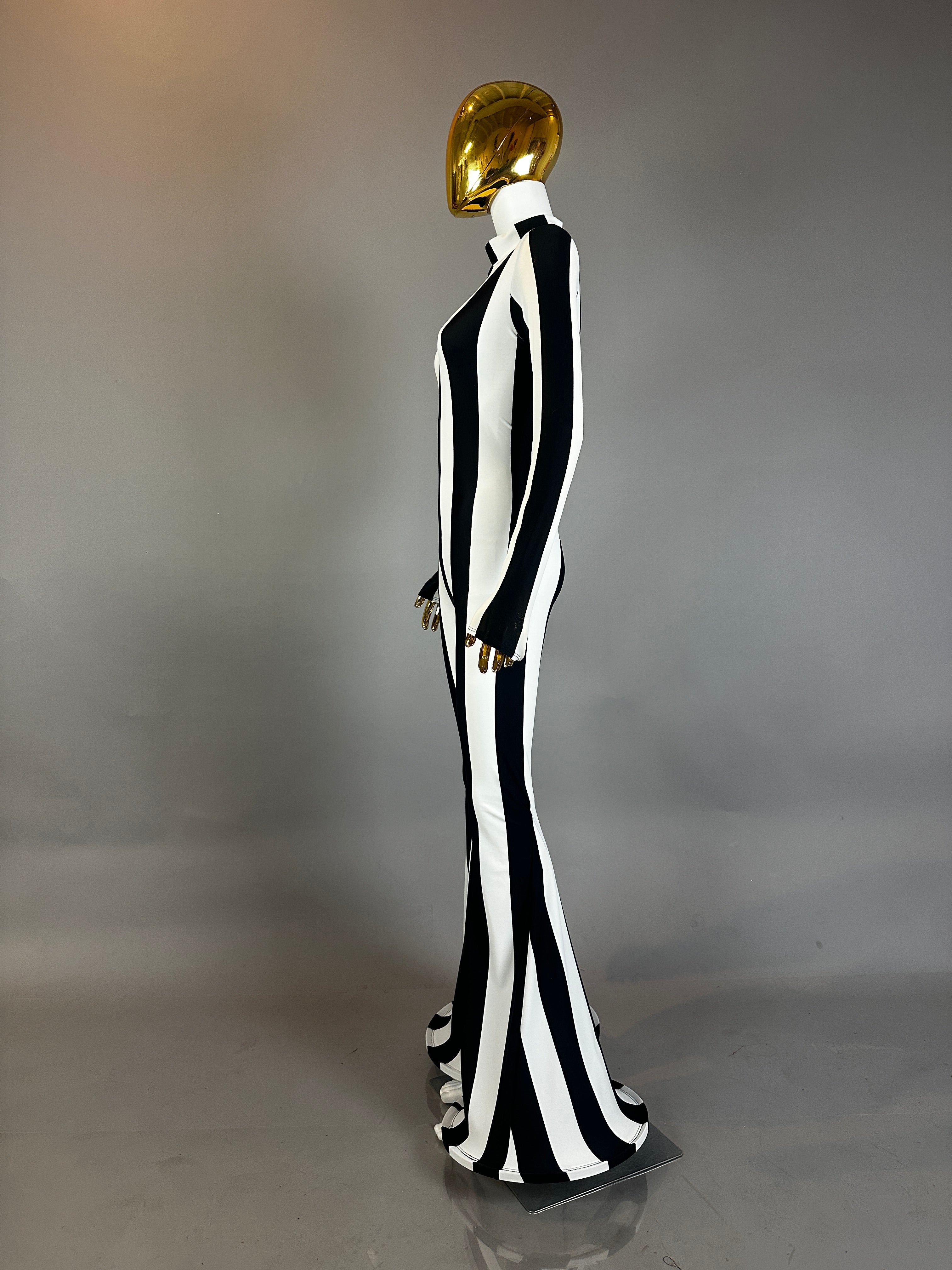 A mannequin in a gold mask wears the Rave White Striped Catsuit with bellbottom legs and long sleeves—a striking outfit for any festival performer.