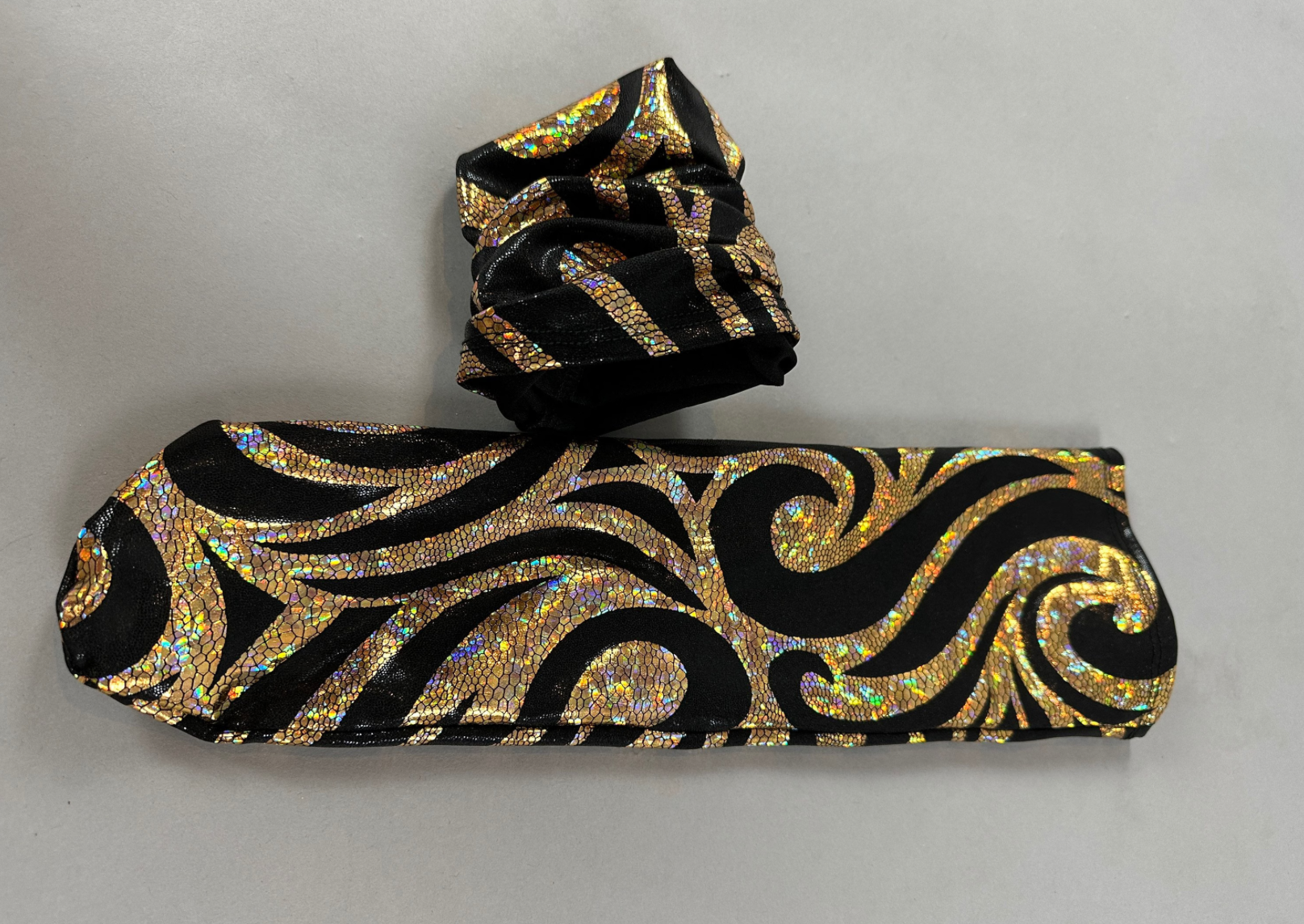 The Alien Full Body Costume Set includes a turtleneck catsuit with black fabric and gold holographic swirls, a folded tie, spiked accessories, and an open-eye headpiece, creating a futuristic alien outfit vibe.