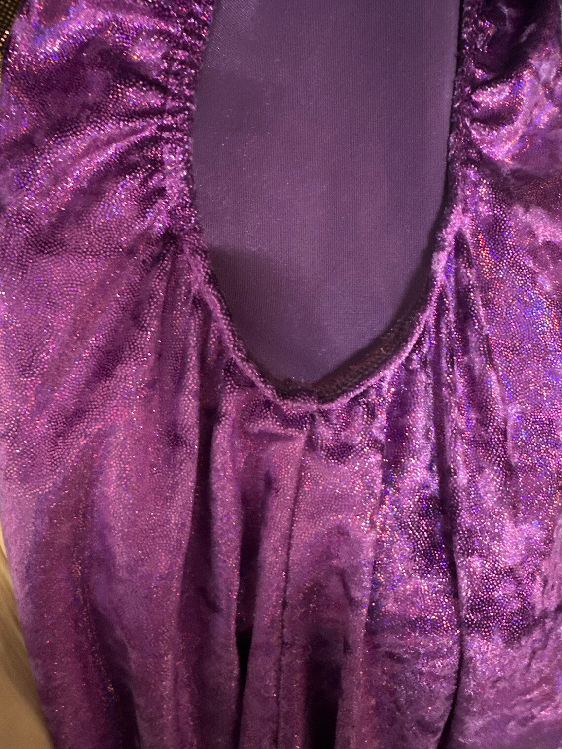 Close-up of the Velvet Open Back Jumpsuit in sparkly purple fabric with a sheer panel and gathered details—exotic dance wear, trending now, perfect for an elegant festival outfit.