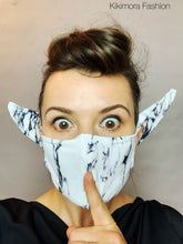 A woman wears the Face Mask, Elf Ears Cosplay Costume Accessory, Breathing Face Mask and holds a finger to her lips in a shushing gesture.