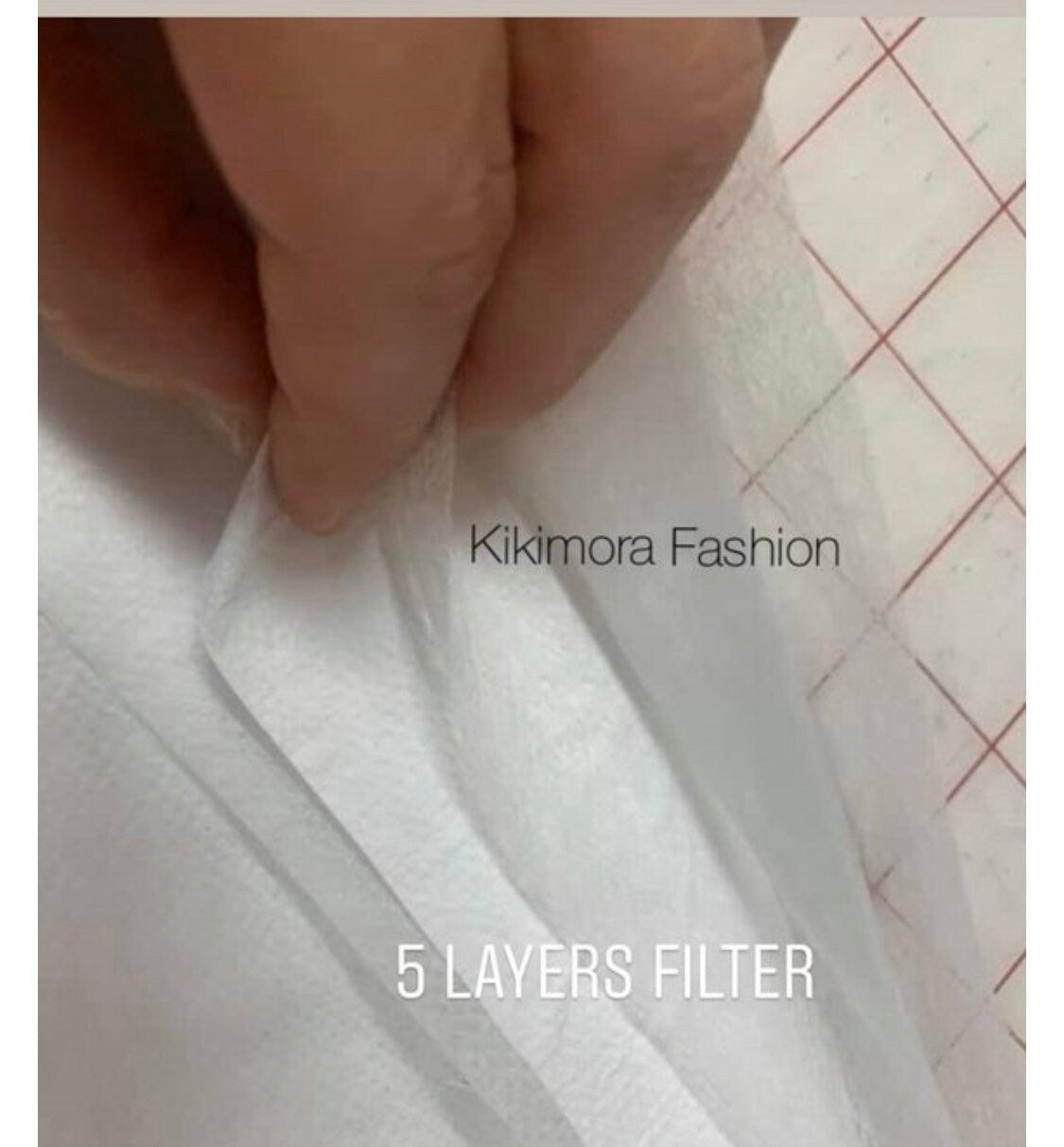 A hand separates layers of white filter fabric labeled "5 LAYERS FILTER" from the Elf Ears Face Mask by Kikimora Fashion, a reusable, sustainable mask inspired by Mandalorian Baby Yoda for all ages.