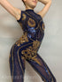 Person posing in a sleeveless, mock turtleneck Blue And Gold Sequin Catsuit, hands behind their head, evoking a gymnastic flair.