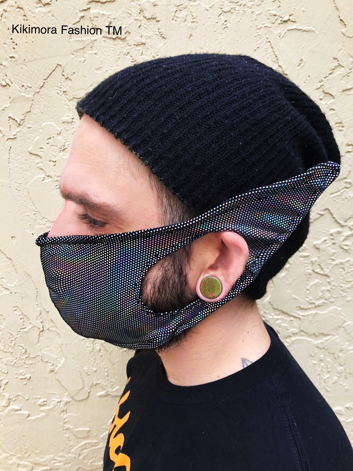 Person in a black beanie and Elf Ears Face Mask for All Ages—an iridescent, funny mask with fabric ear loops by Kikimora Fashion, inspired by Mandalorian Baby Yoda and made in the USA.