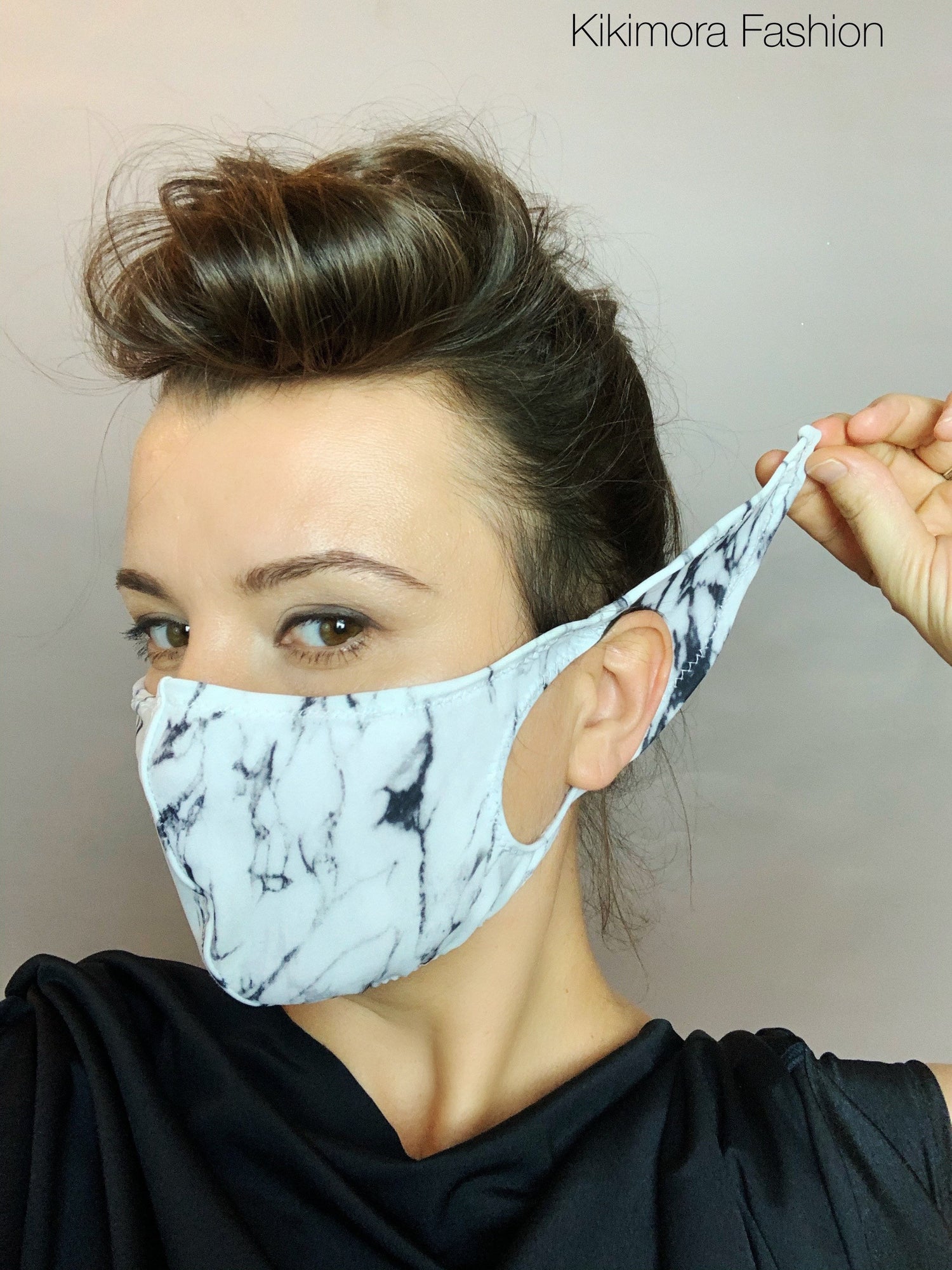Woman wearing a white marble-pattern Face Mask, Elf Ears Cosplay Costume Accessory made from Lycra, pulling one strap; "Kikimora Fashion" text in top right.