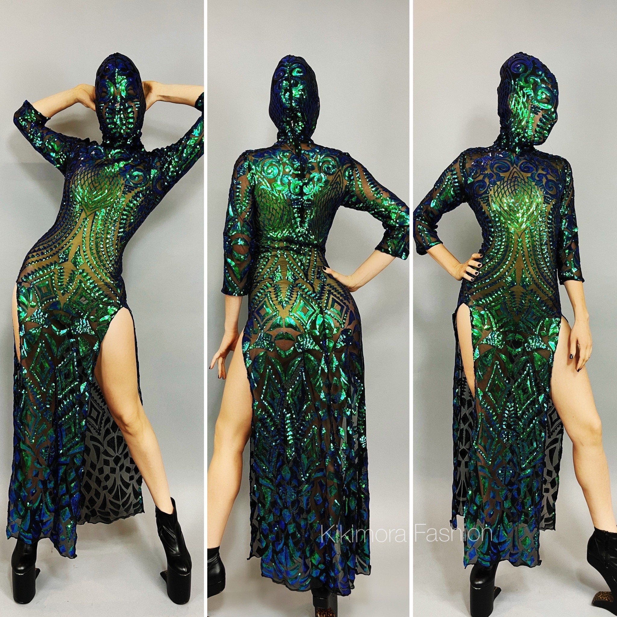 A person wears the Beautiful Sequins Dress, a stunning green and blue festival fashion piece with side slits and an alien headpiece, posing against a gray background in black boots.