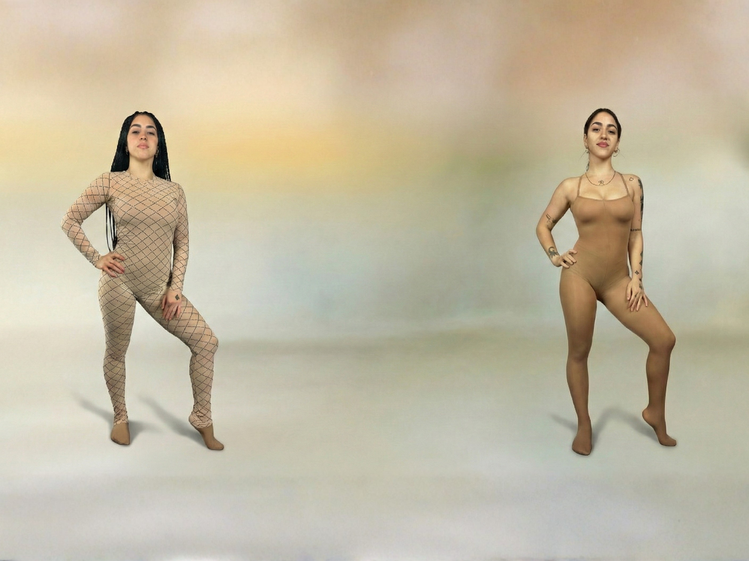Two women in beige bodysuits pose against a soft, blurred background, standing apart from each other.