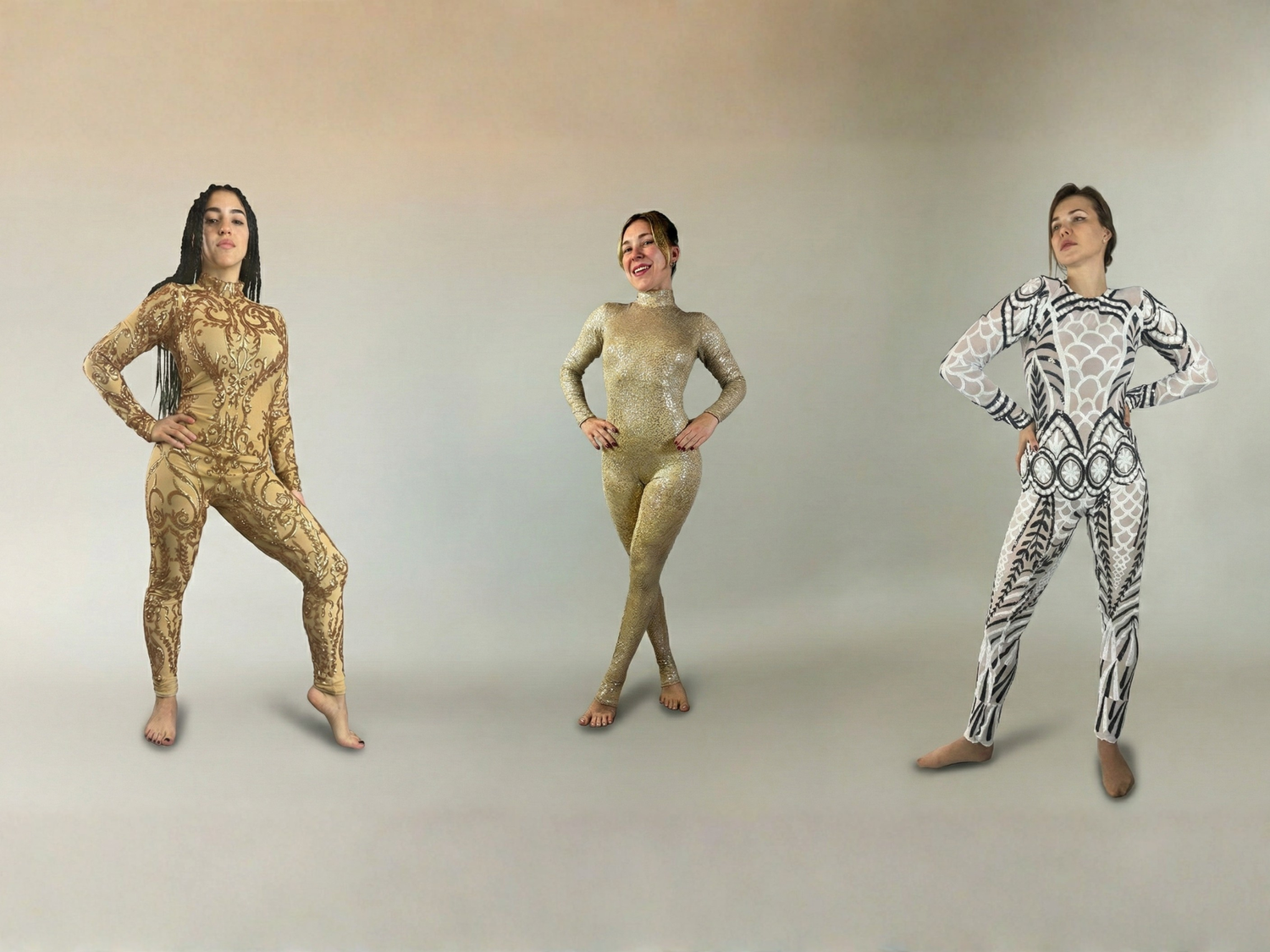 Three women in patterned bodysuits stand confidently against a neutral background, hands on hips.
