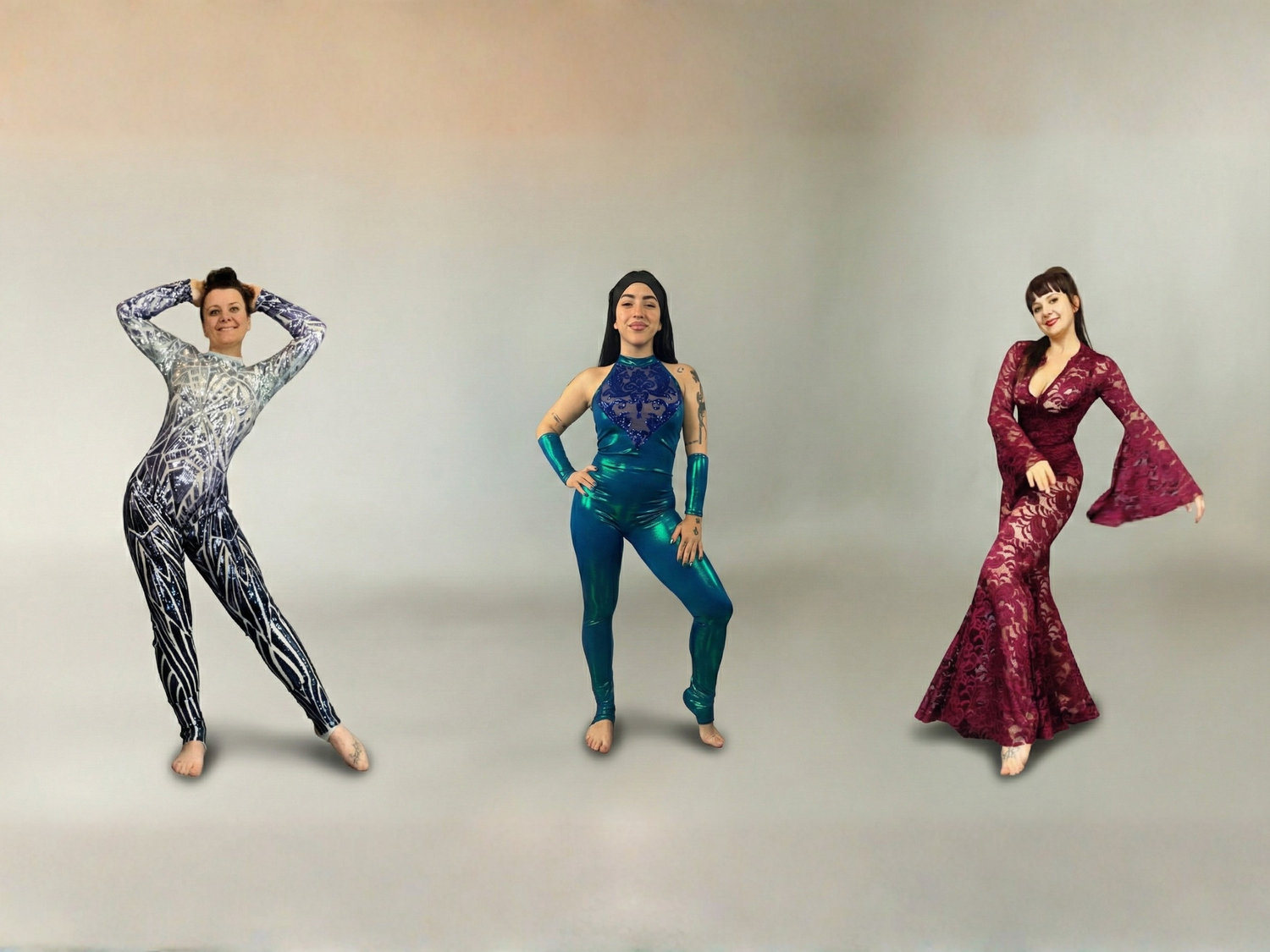 Three women in colorful dance costumes pose confidently against a neutral background.