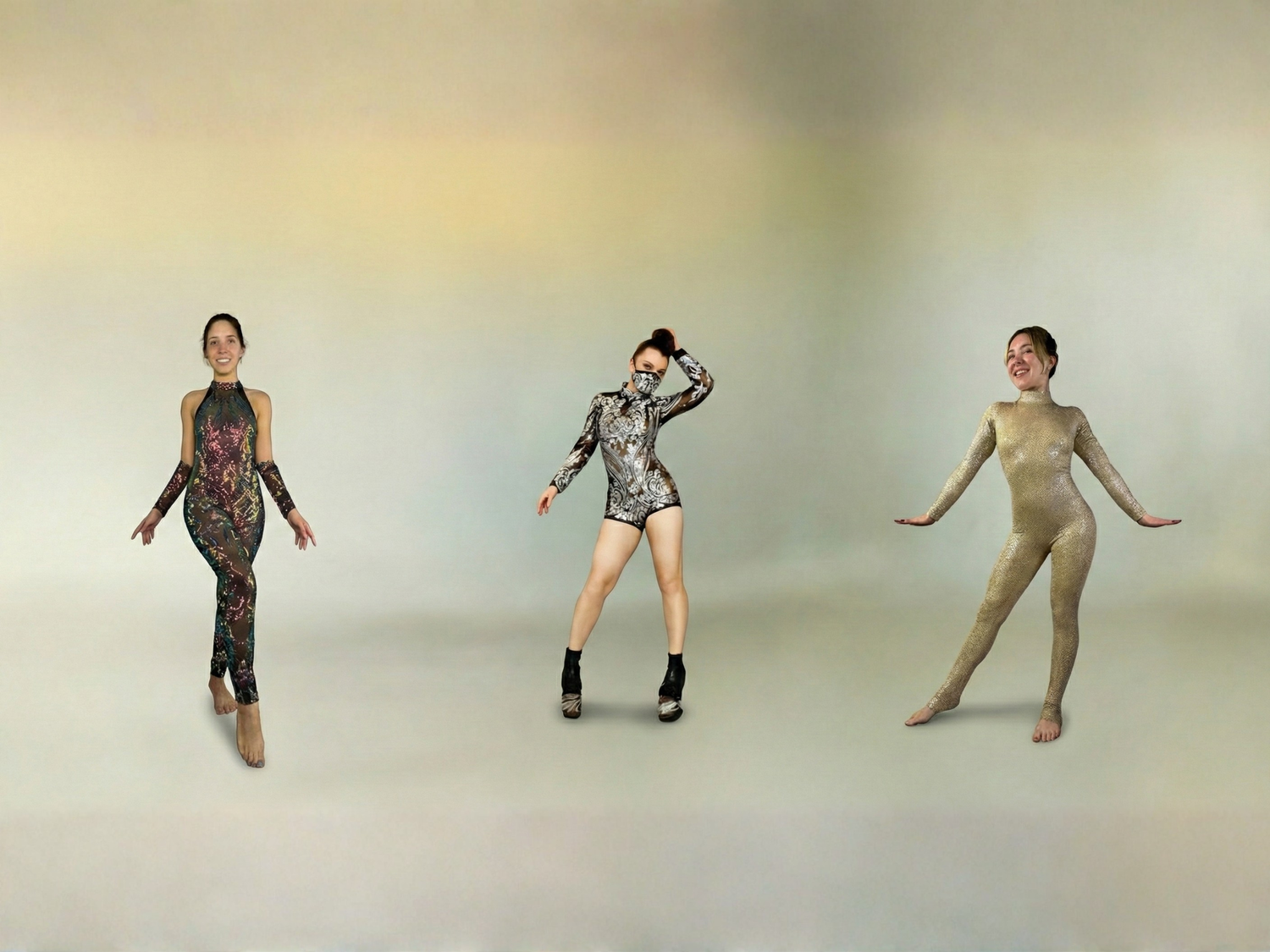Three women in patterned dance costumes pose against a plain, light-colored background.