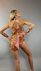 A person models the Fire color sparkling Halter Leotard with sequin accents and detachable sleeves, facing away with hands on hips against a gray background.