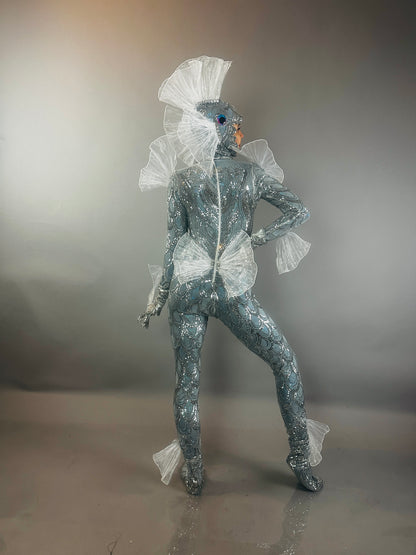The Sea Creature is a silver, shiny, textured bodysuit with fins that creates a dazzling, futuristic aquatic look—a wearable sculpture and striking costume.