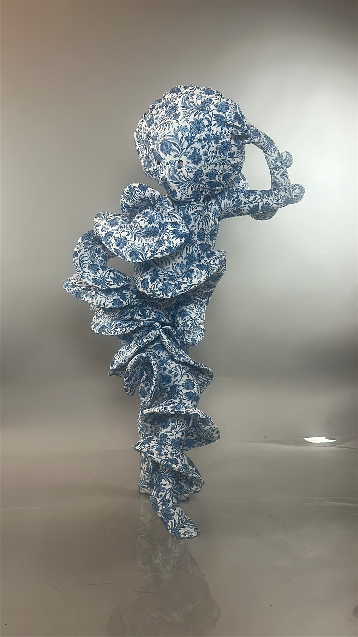 A figure clad in the Mushroom Creature Costume—an avant-garde full body suit crafted from marble print spandex—strikes a dramatic, sculptural pose against a gray background. The artistic fungus costume features blue-and-white patterns reminiscent of mushrooms and is custom fit for performance or UV glow wear.