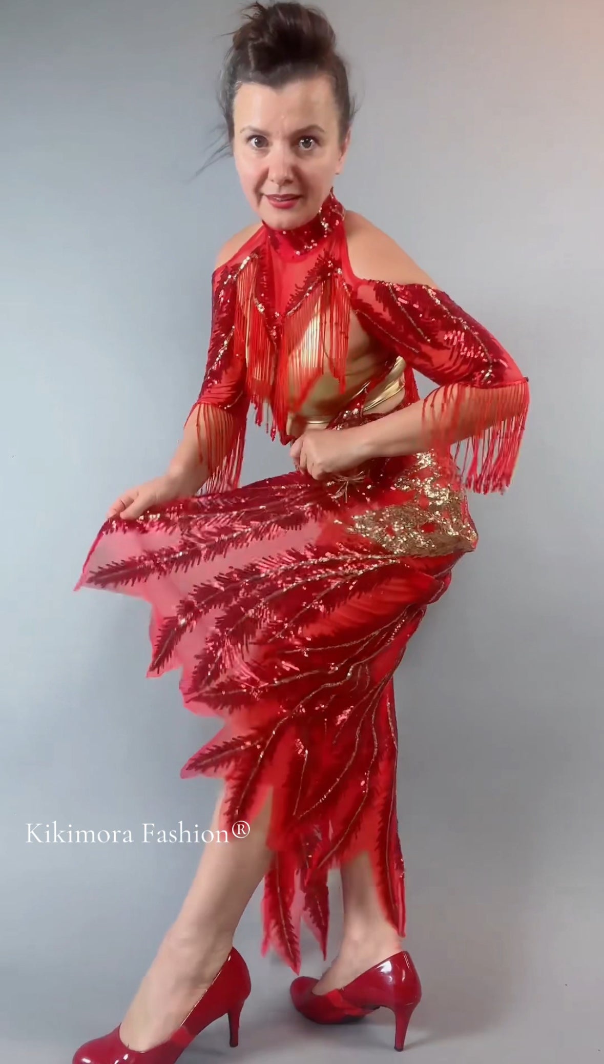 Woman models the bearded French accessories Sequin Sheer Dress, featuring a backless design and beaded fringe accessories, against a plain background.