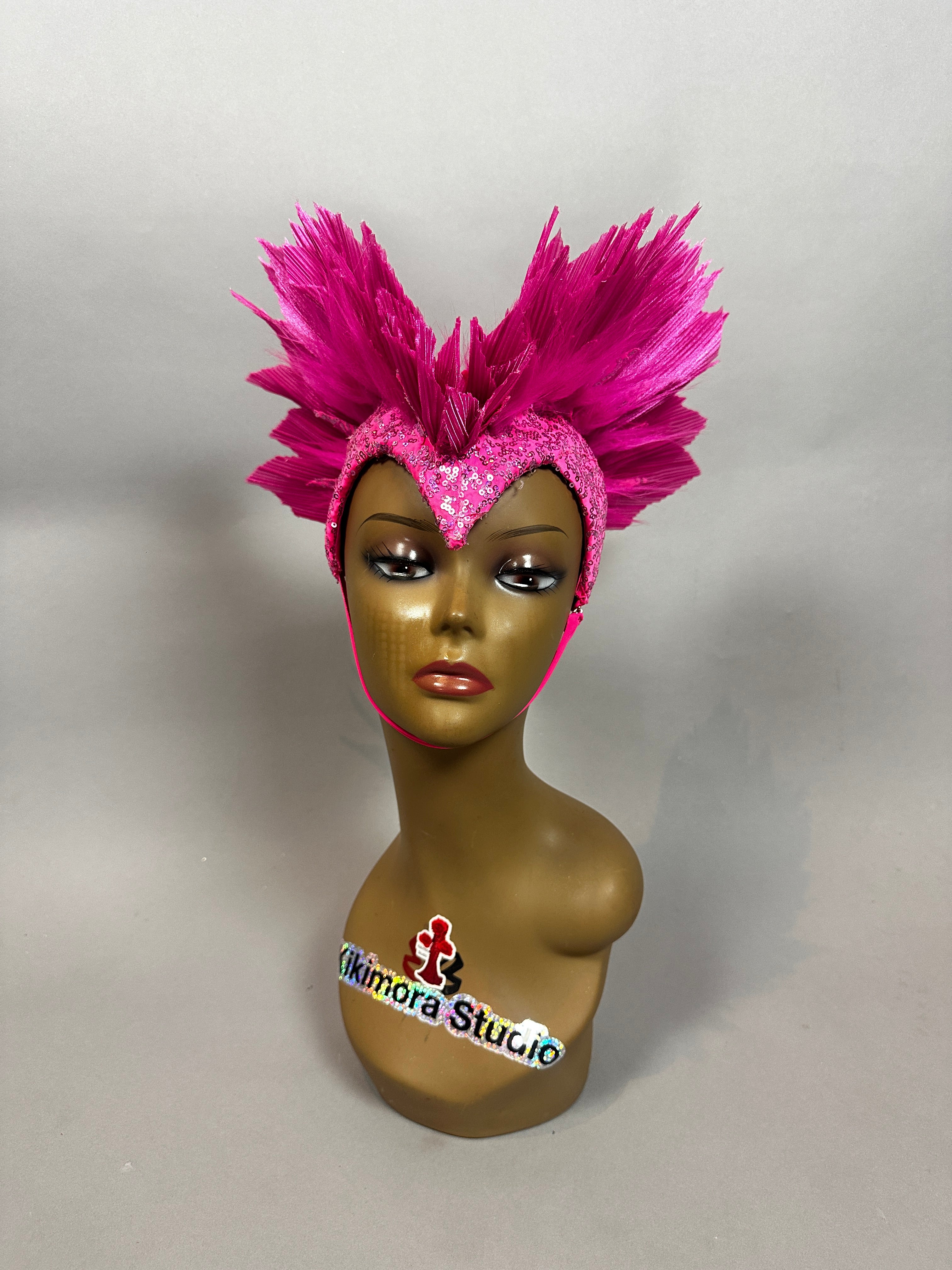 Mannequin wearing the Pink Bird Headpiece—an eye-catching fairy hat for aerialists and theatrical use—featuring a heart-shaped front, pink sequins, and feathered accents, set against a plain background.