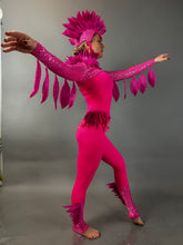 Person in a Pink bird full costume for aerial and dancers poses with arms outstretched against a plain gray background, highlighting the vibrant design of this theatrical show outfit.