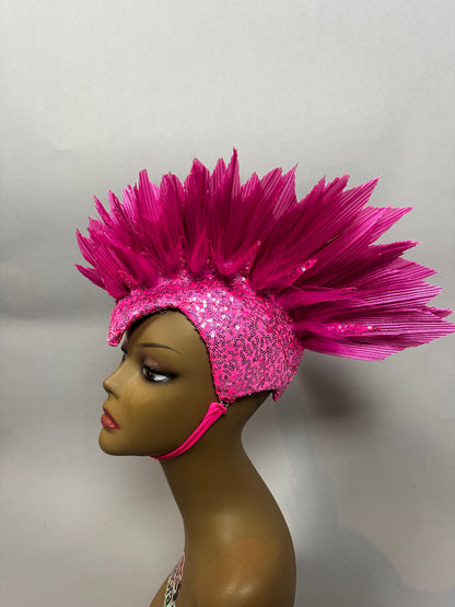 A mannequin wears the Pink Bird Headpiece—a fairy hat with dramatic, spiked feather details—styled as theatrical headwear for an enchanting, aerialist-inspired look.