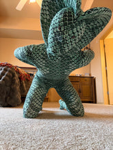 Person wearing a Green pixel Cobra Costume—snake print catsuit with headdress—kneeling on a bedroom carpet, resembling a reptilian creature.