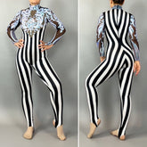 A person in the Glamorous sequins Stripes Catsuit costume, featuring black-and-white vertical stripes, sheer sleeves, blue ornamental chest detailing, and a sequined leaf design.