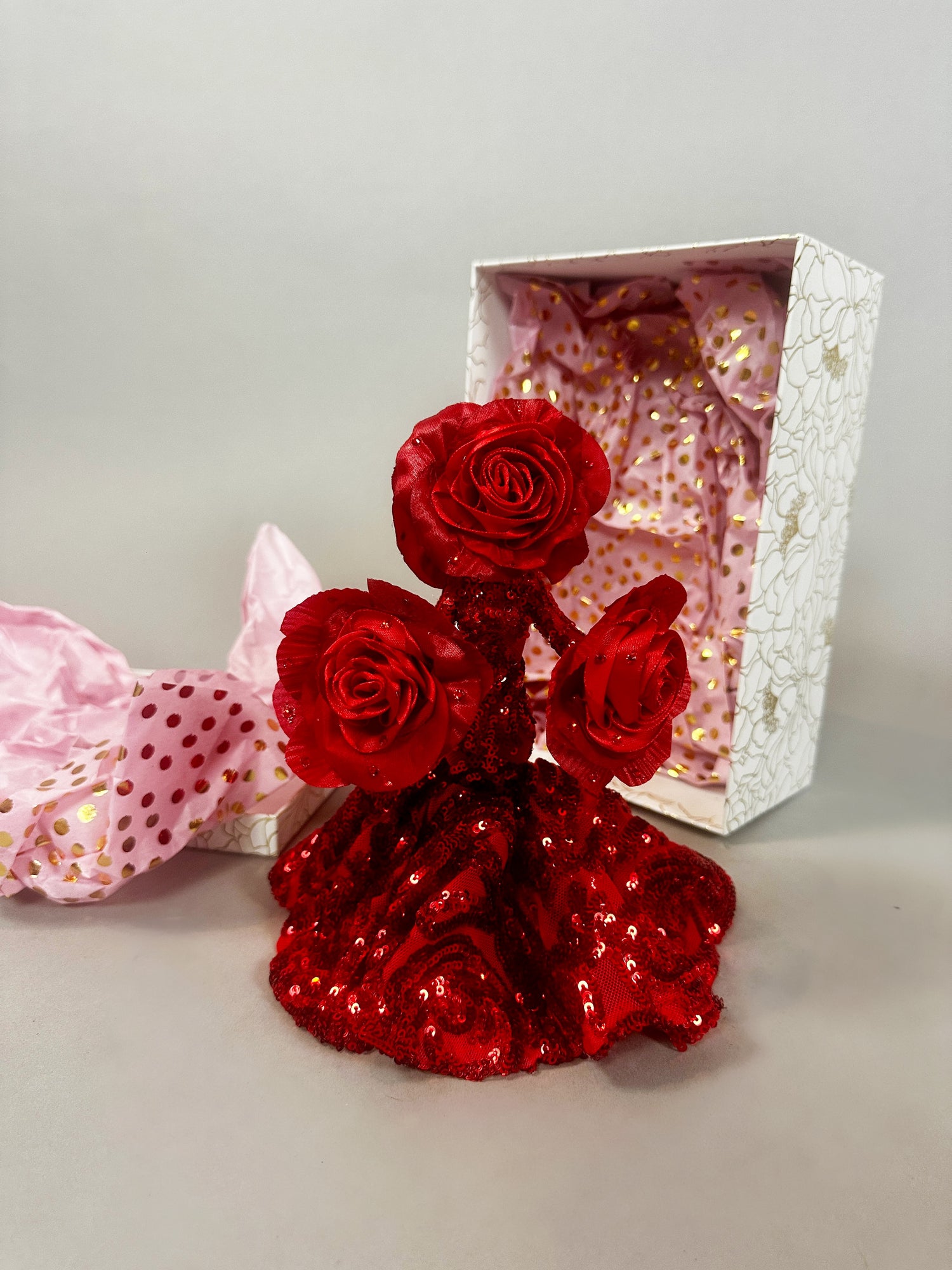 The Mini Living Rose sculpture is a handcrafted doll ornament featuring three red roses in a dress shape, displayed with a Kikimora Studio decorative box lined with pink fabric.