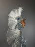 Model is wearing the Sea Creature costume, featuring a shiny silver finish, fin-like headpiece, and iridescent details—a stunning display of couture design.