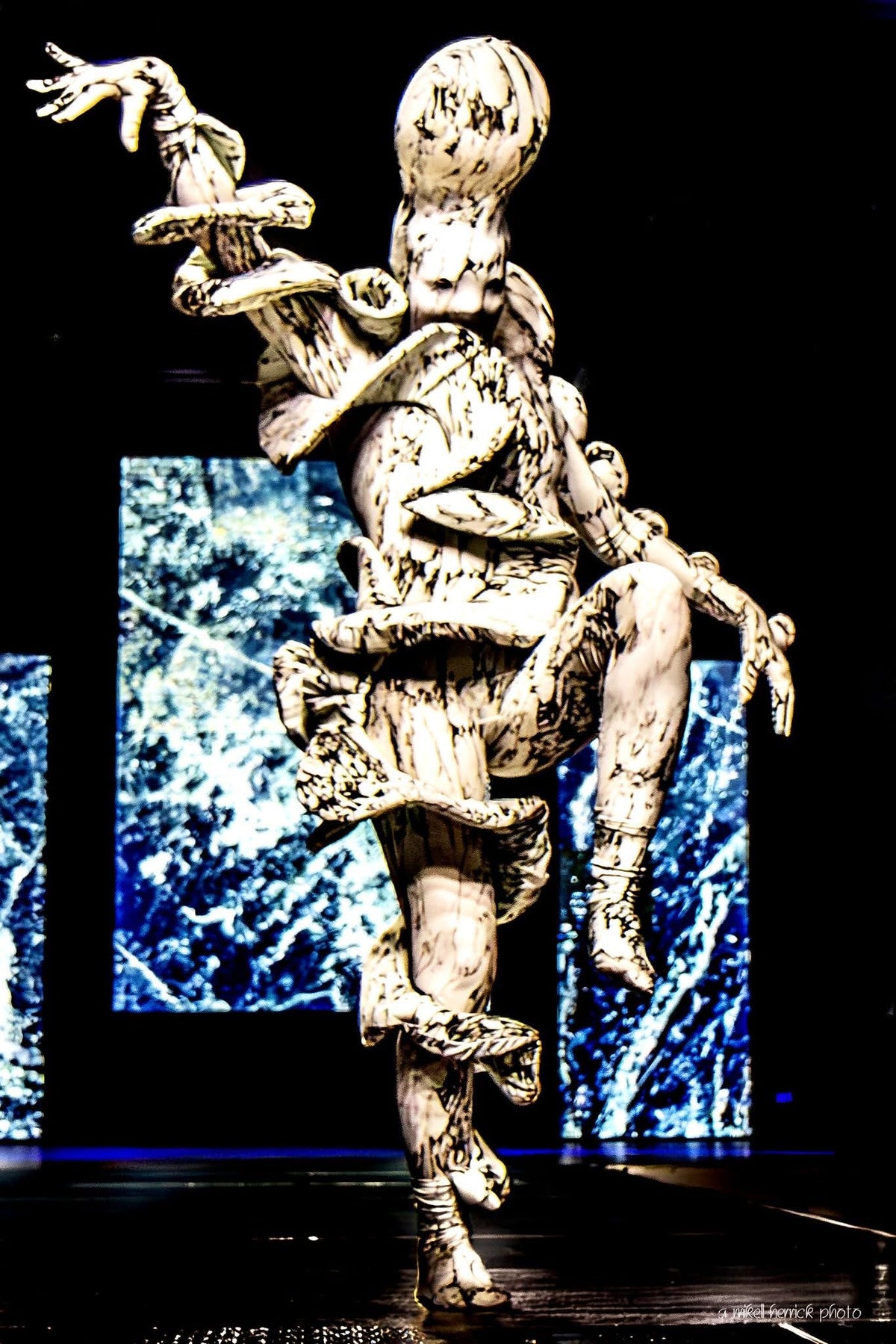 Avant-garde full body suit featuring a marble print spandex design, this Mushroom Creature Costume showcases exaggerated limbs and textured, fungus-inspired patterns, striking a dramatic pose—ideal as artistic UV glow performance wear or a custom-fit statement piece.