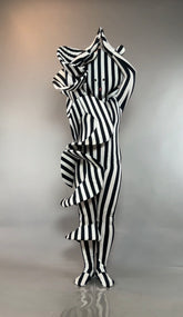 Person in a Black and White Striped Creature Costume with Sculptural Details, featuring large ruffles and a face mask.