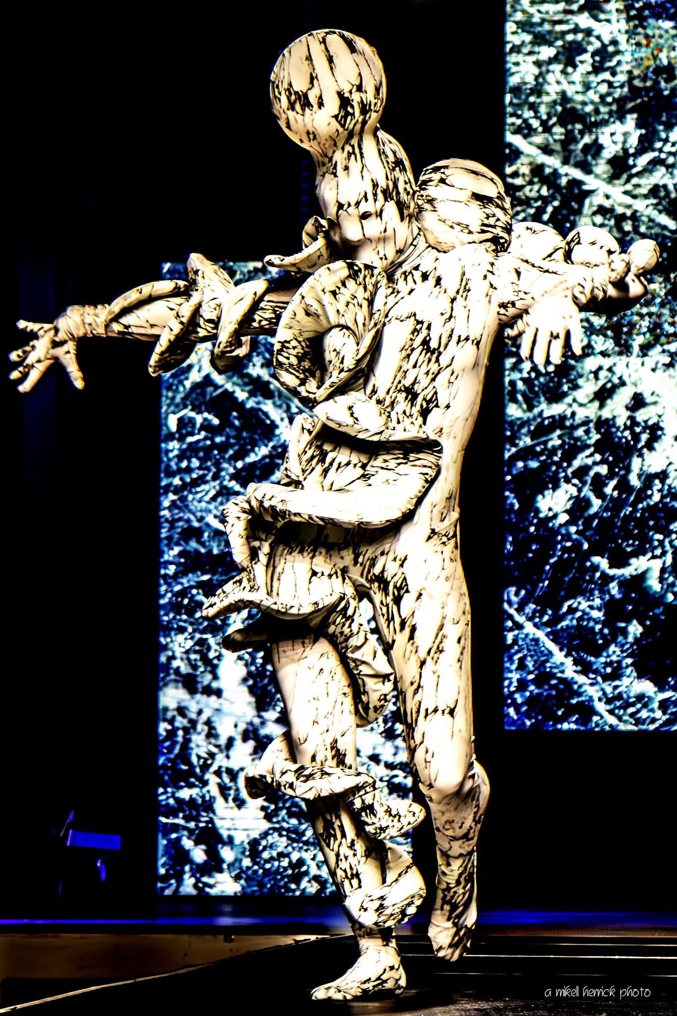 Two performers take the stage in artistic Mushroom Creature Costumes, wearing avant-garde full body suits crafted from marble print spandex that glow under UV light.