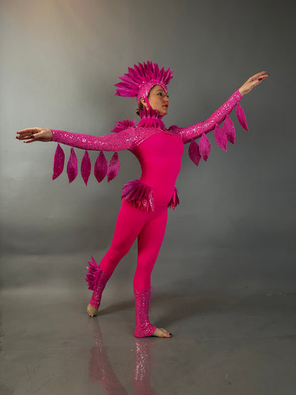 A dancer showcases the Pink bird full costume for aerial and dancers, featuring a bright pink design with a feathered headpiece and wing-like sleeves, perfect for theatrical performances.