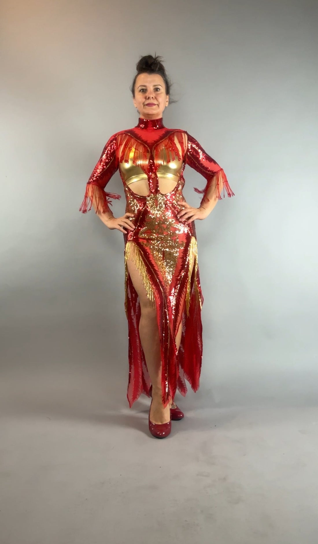 Woman wearing the bearded French accessories Sequin Sheer Dress—backless, with beaded fringe accessories—poses elegantly against a plain gray background.