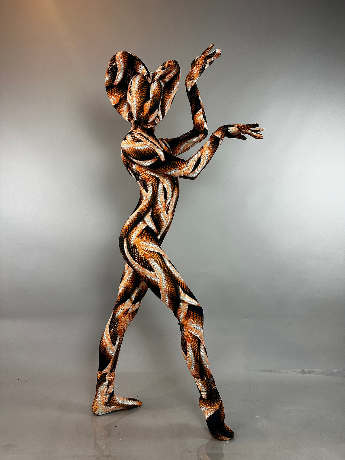 A person wearing a Brown Snake Print Turtleneck Catsuit with Back Zipper in a brown and black pattern.