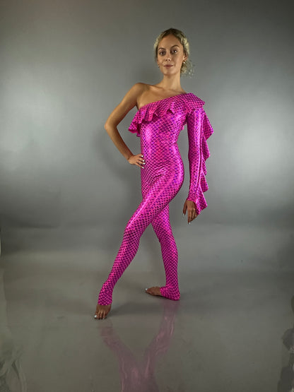 Woman poses in a shiny red off-shoulder spandex ruffle catsuit bodysuit with an asymmetrical design, set against a plain gray background.