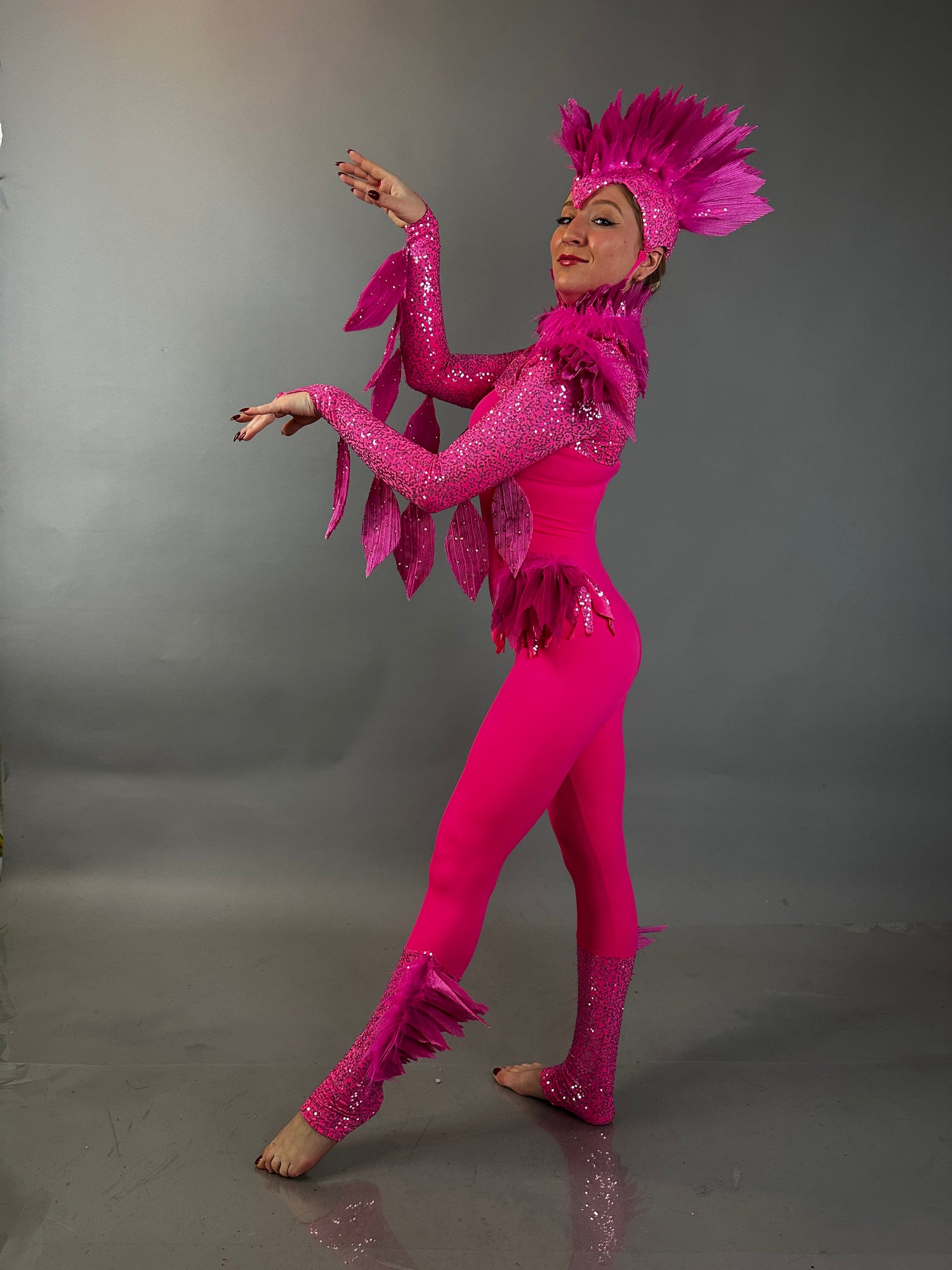 Model elegantly displays the Pink bird full costume for aerial and dancers, featuring vibrant pink feathers, set against a simple grey background—ideal for standout theatrical performances.