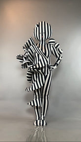 A person wearing a Black and White Striped Creature Costume with sculptural ruffles, a matching mask, and headpiece.