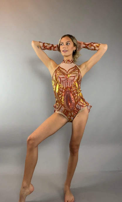 A woman poses against a plain gray background, looking to the side, wearing the Fire color sparkling Halter Leotard with sequin accents and detachable sleeves.