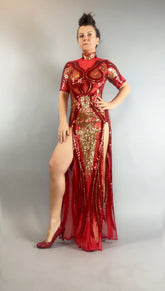 Confident woman in a Red and Gold Sequin Sheer Dress, sleeveless, styled with hand accessories and matching heels, striking a stylish pose.