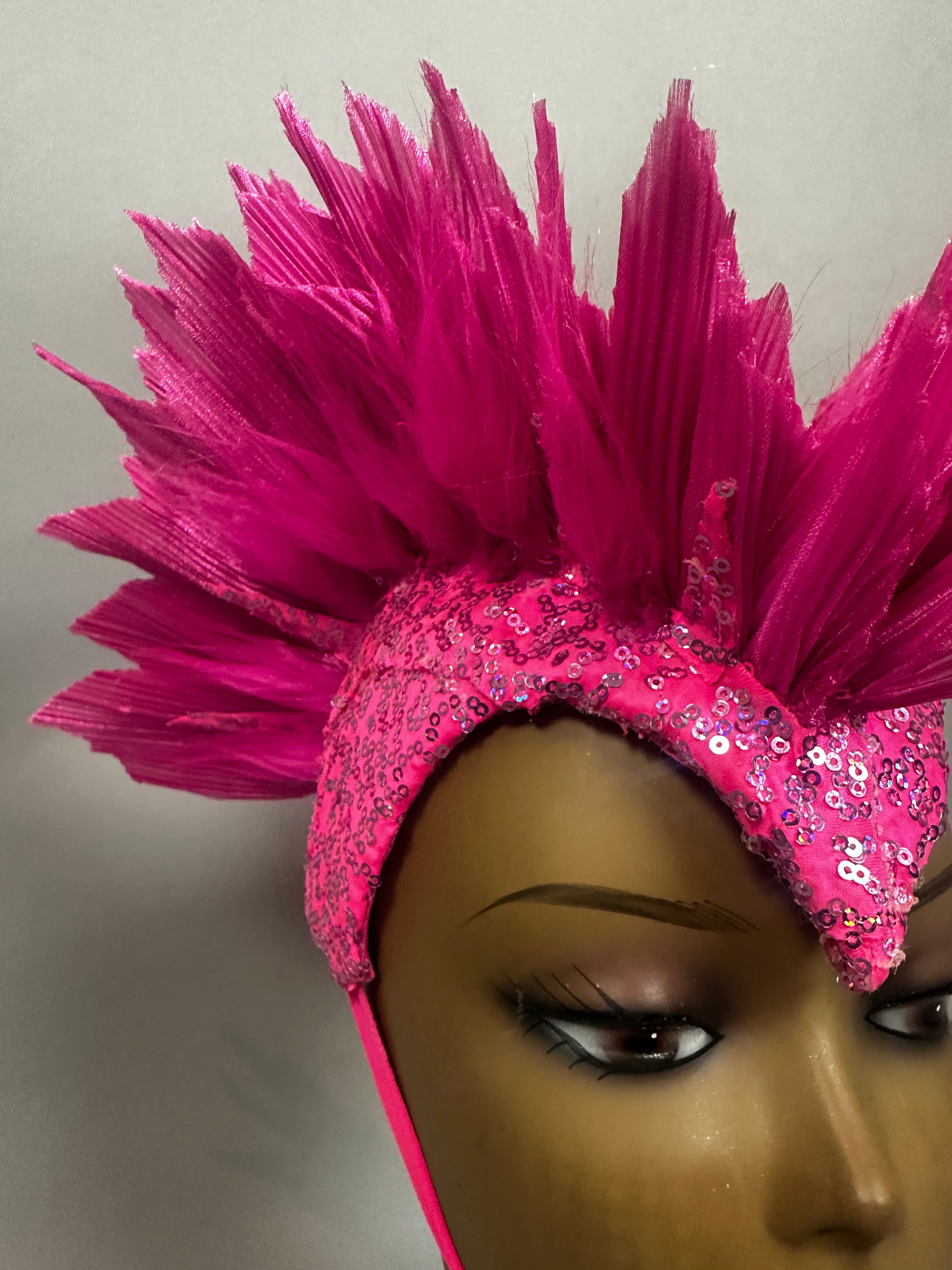 Mannequin head wearing the Pink Bird Headpiece, a spiky pink Fairy Hat with sequins, ideal for aerialists and theatrical headwear, shown against a plain background.