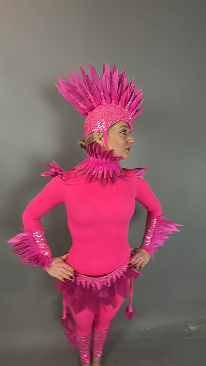 Person wearing the Pink Bird Headpiece, a fairy hat accessory with feathered accents, styled as aerialist headwear and theatrical costume prop, standing against a plain gray background.