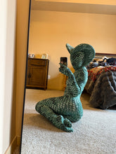 Wearing the Green pixel Cobra Costume—snake print catsuit, headdress, and custom-made unitard—this person poses in front of a mirror on a carpeted floor.