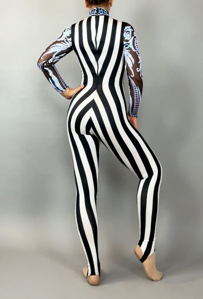 A person wears the Glamorous sequins Stripes Catsuit costume, featuring black and white vertical stripes, sheer patterned sleeves, and a sequined leaf design, shown from the back.