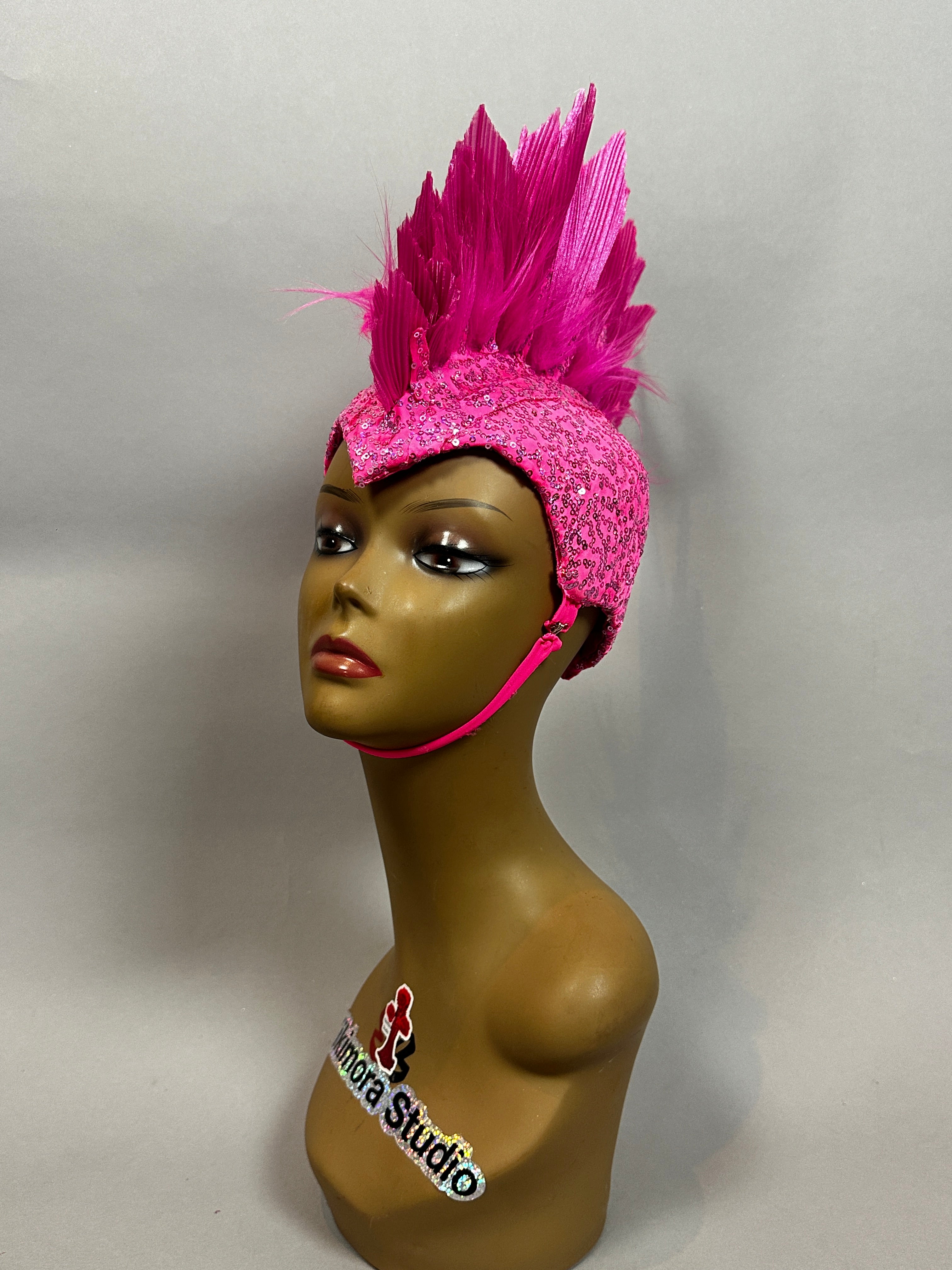 Mannequin head displays the Pink Bird Headpiece—feathered helmet with chin strap—Fairy Hat Accessory, Aerialist Headwear, perfect for theatrical costumes, festivals, or rave outfits. Plain background enhances this bold prop.