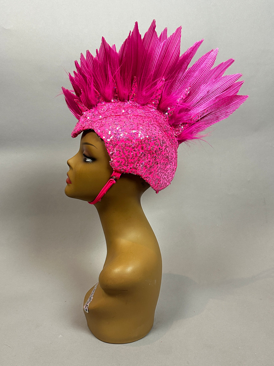 Mannequin head in side profile displays the Pink Bird Headpiece—an eye-catching fairy hat accessory with bright pink spikes, sequin details, perfect for aerialists, theatrical costumes, festivals, and rave outfits.