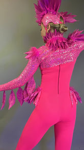 Person wearing the Pink bird full costume for aerial and dancers, featuring bright pink feathers and sparkly details, with headpiece, shown from the back against a plain background.