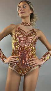 A model poses confidently against a plain gray background wearing the Fire color sparkling Halter Leotard with sequin accents and detachable sleeves.