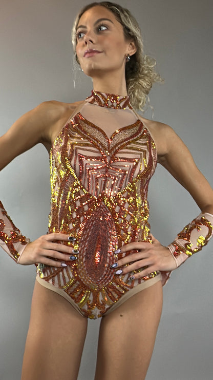 A model poses confidently against a plain gray background wearing the Fire color sparkling Halter Leotard with sequin accents and detachable sleeves.
