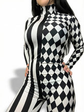 Woman poses with hands on hips in a Black and White Split Fabric Catsuit featuring full sleeves, turtleneck, bold stripe and diamond patterns.