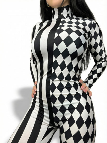Woman poses with hands on hips in a Black and White Split Fabric Catsuit featuring full sleeves, turtleneck, bold stripe and diamond patterns.