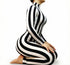 Model kneeling in a Black and White Striped Catsuit with full sleeves and turtleneck, designed to contour the body, against a white background.